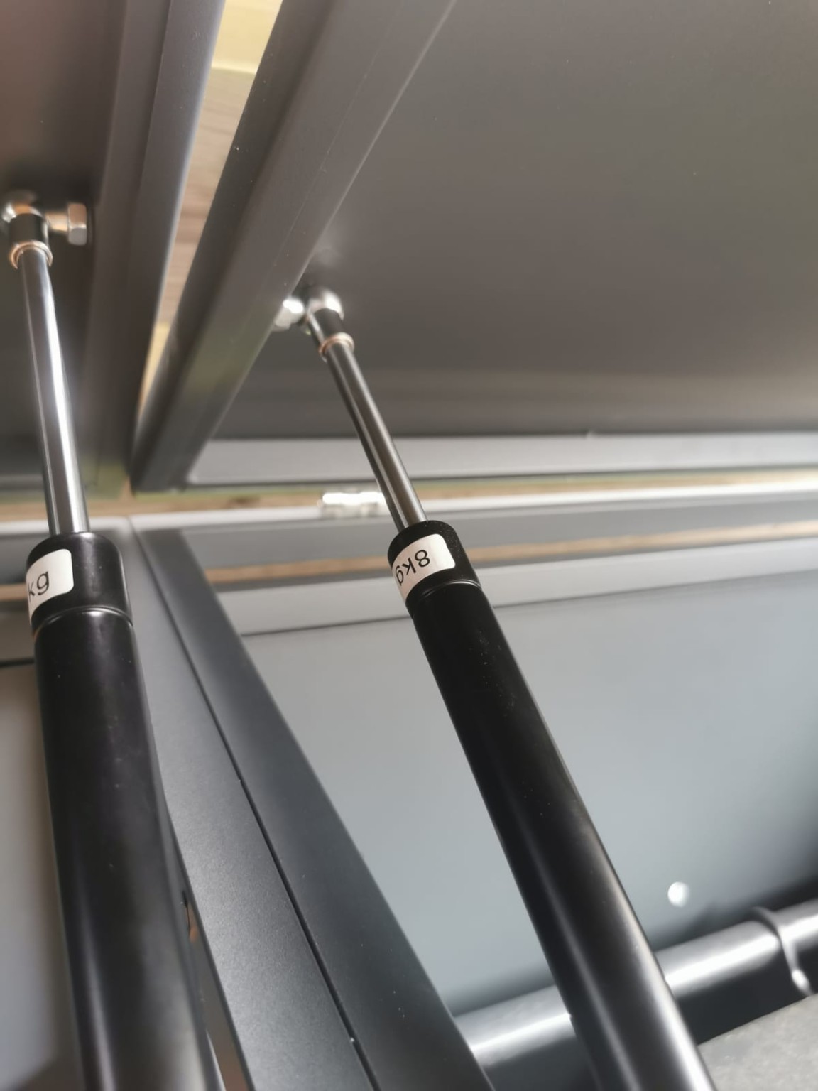 Gas strut on the inside of the steel lid